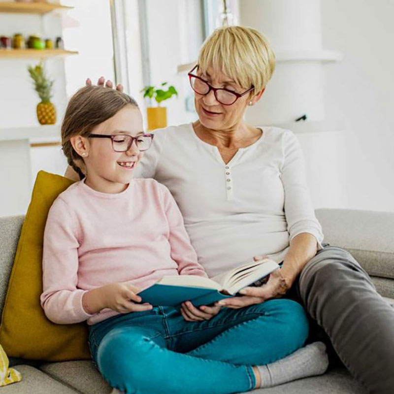 Grandmother with hearing loss reading with her granddaughter.